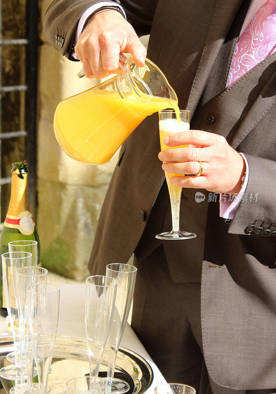 新郎在婚礼上倒橙汁，香槟杯/笛子，起泡酒